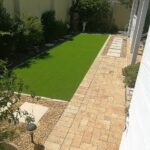 Artificial lawn and pavers surrounded by pebbles